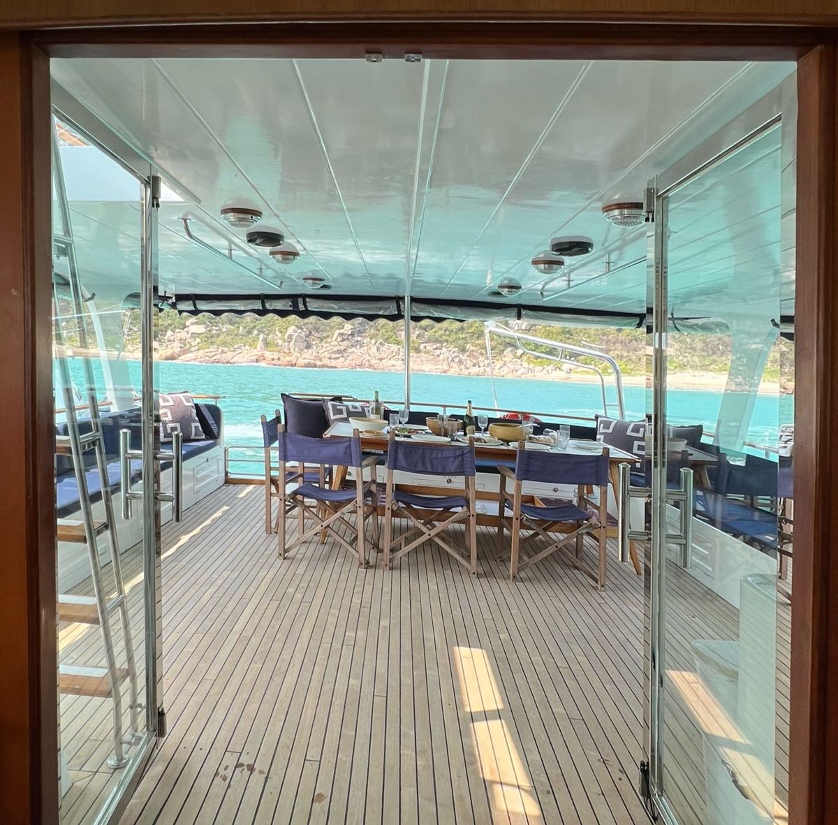 Looking out through the saloon doors to the aft deck table and the sea