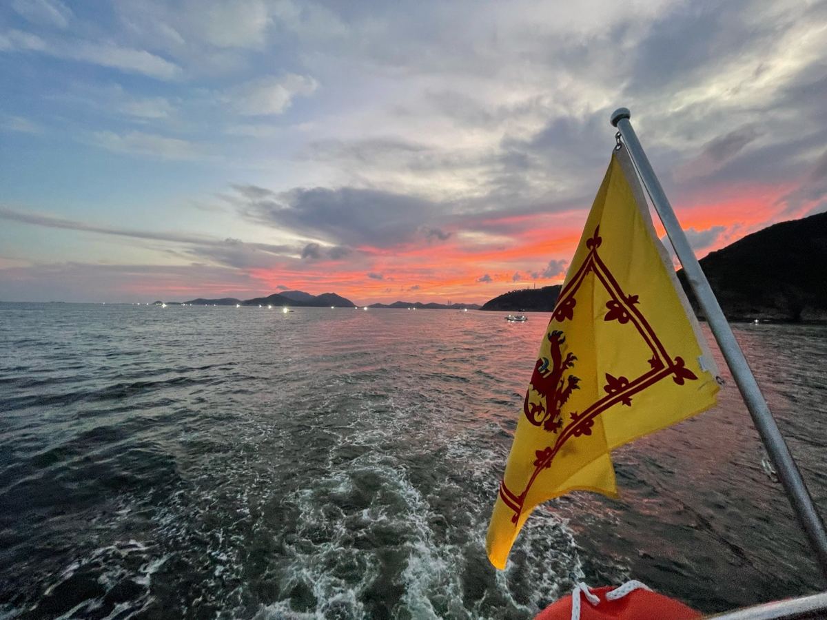 Sunset over the wake with a flag flying